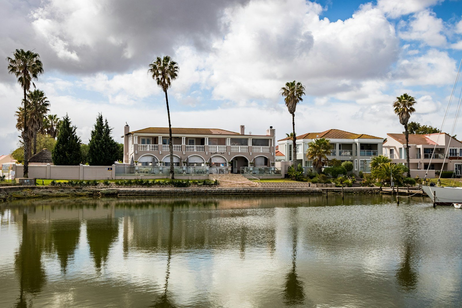 white and brown concrete building near body of water under cloudy sky during daytime